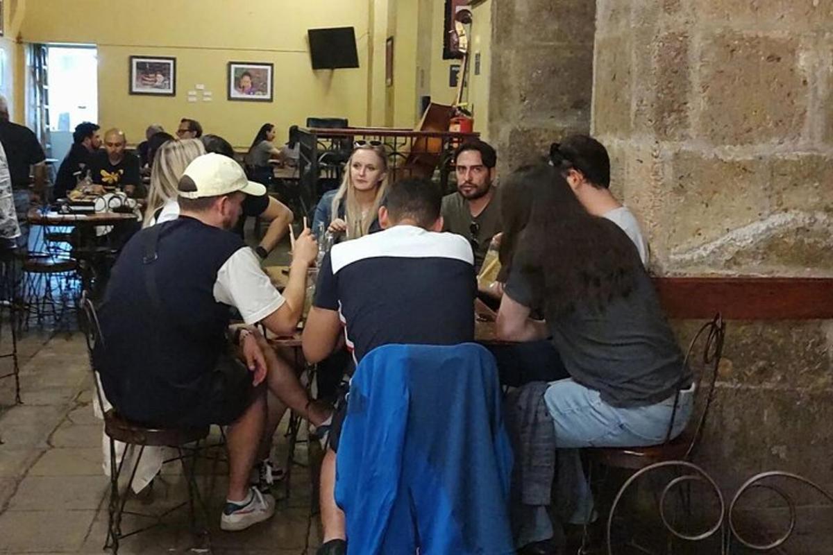 μια ομάδα ανθρώπων που κάθονται γύρω από ένα τραπέζι σε ένα εστιατόριο