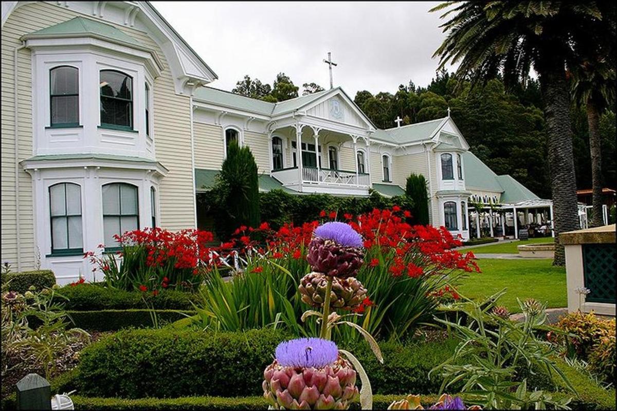 a large white house with flowers in a garden