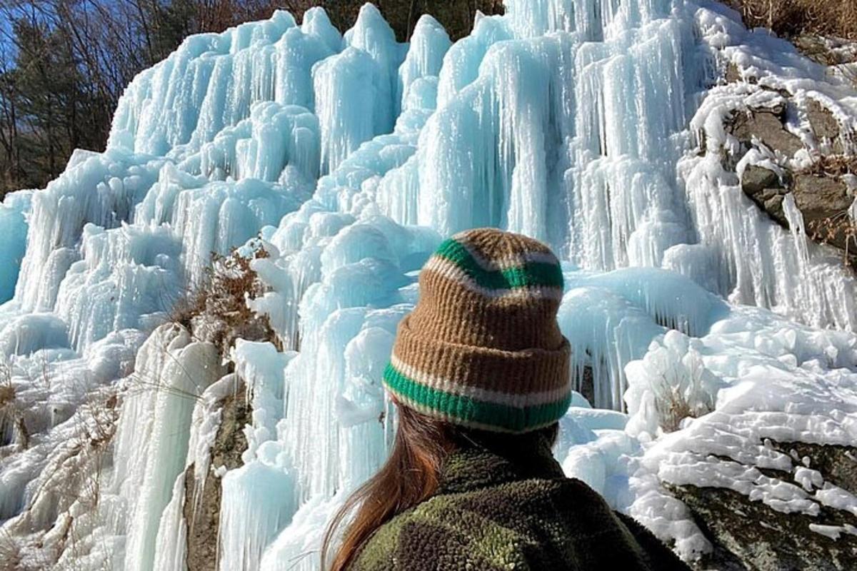 Una mujer está mirando una cascada de hielo.