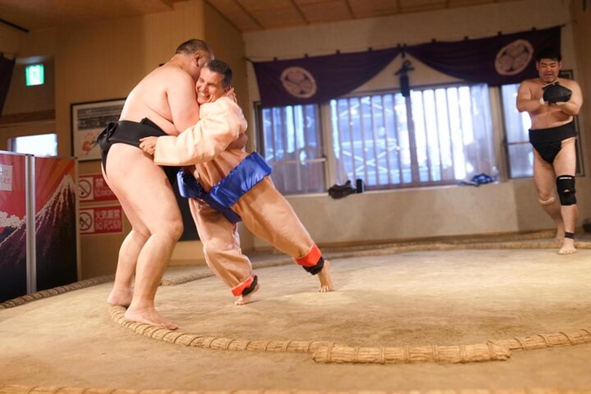 dos lluitadors de sumo abraçant-se al ring