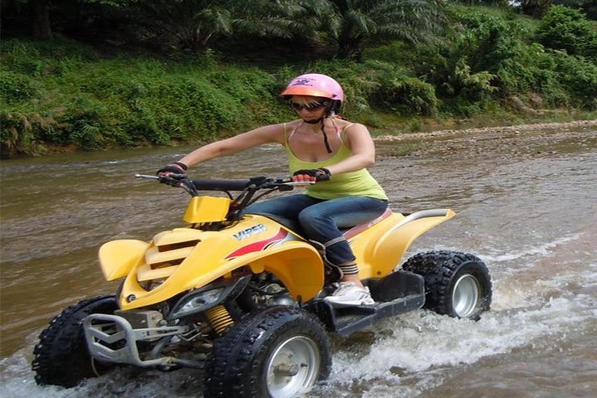 a woman riding a atv through a river
