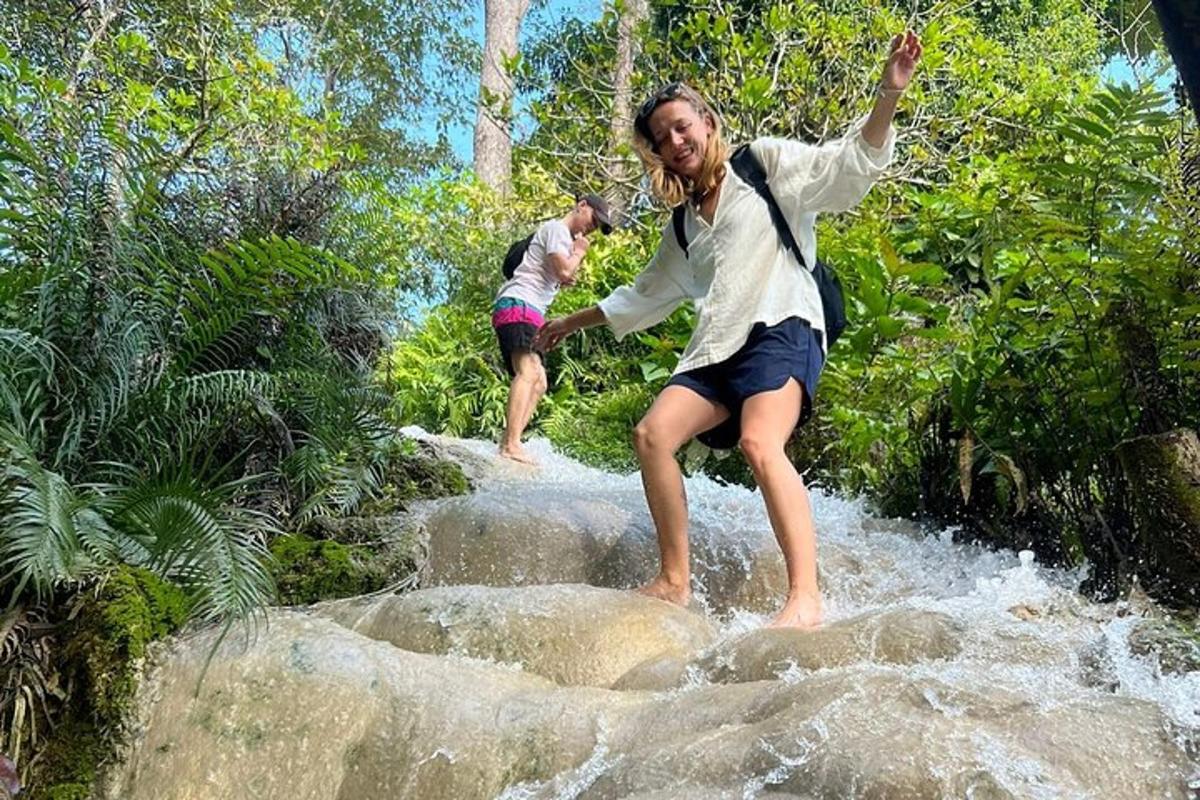 duas pessoas estão em pé sobre pedras na água