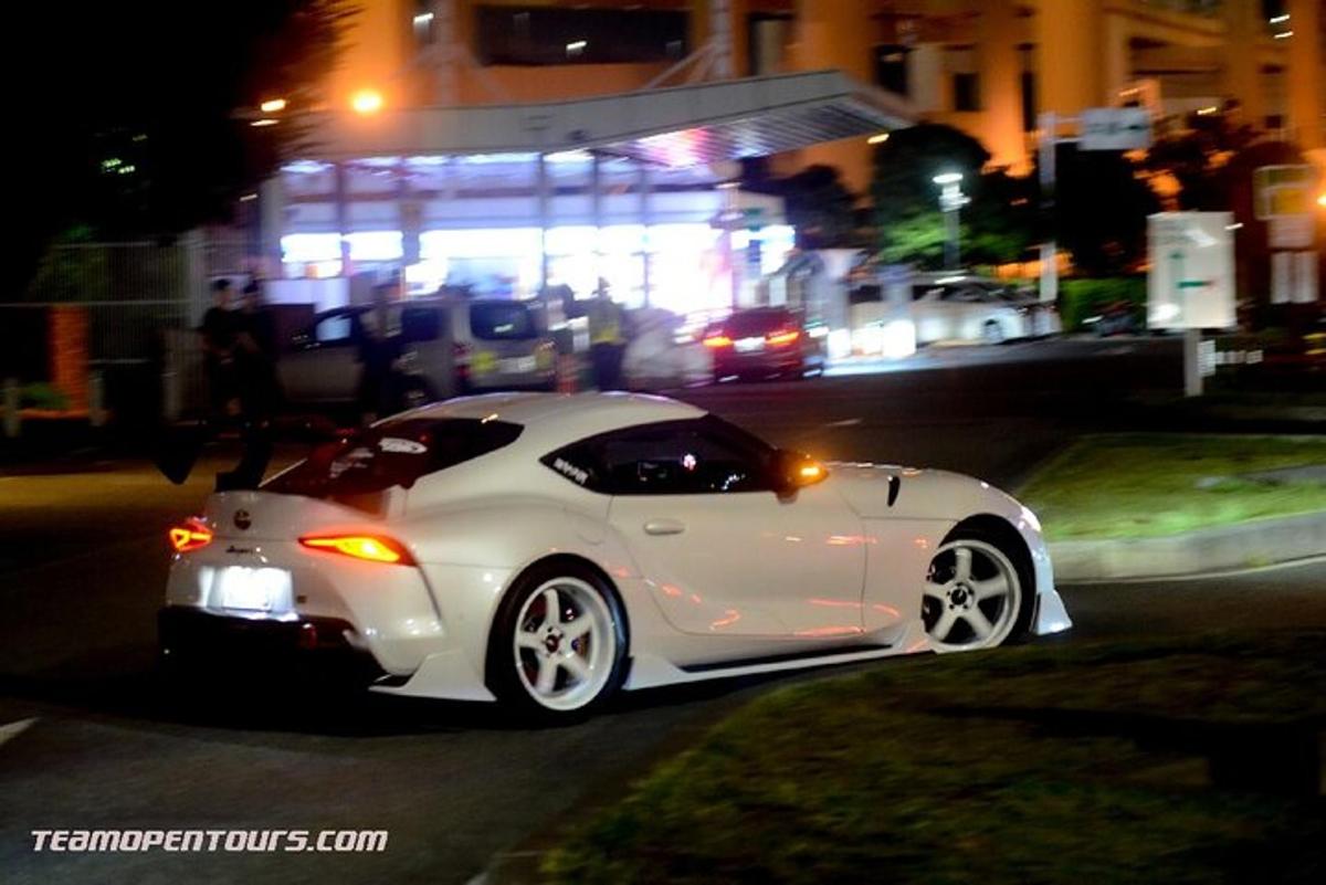 a white car parked on a street at night
