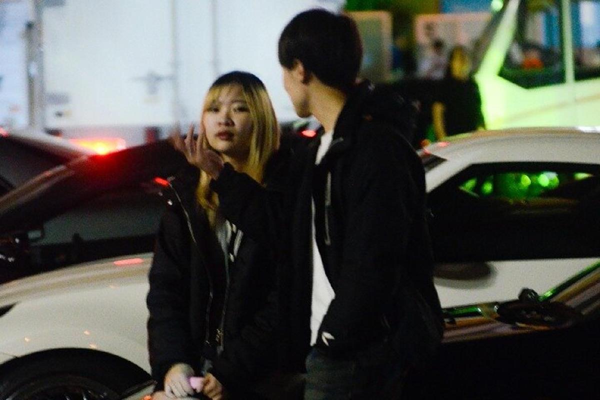 a man and a woman standing next to a car