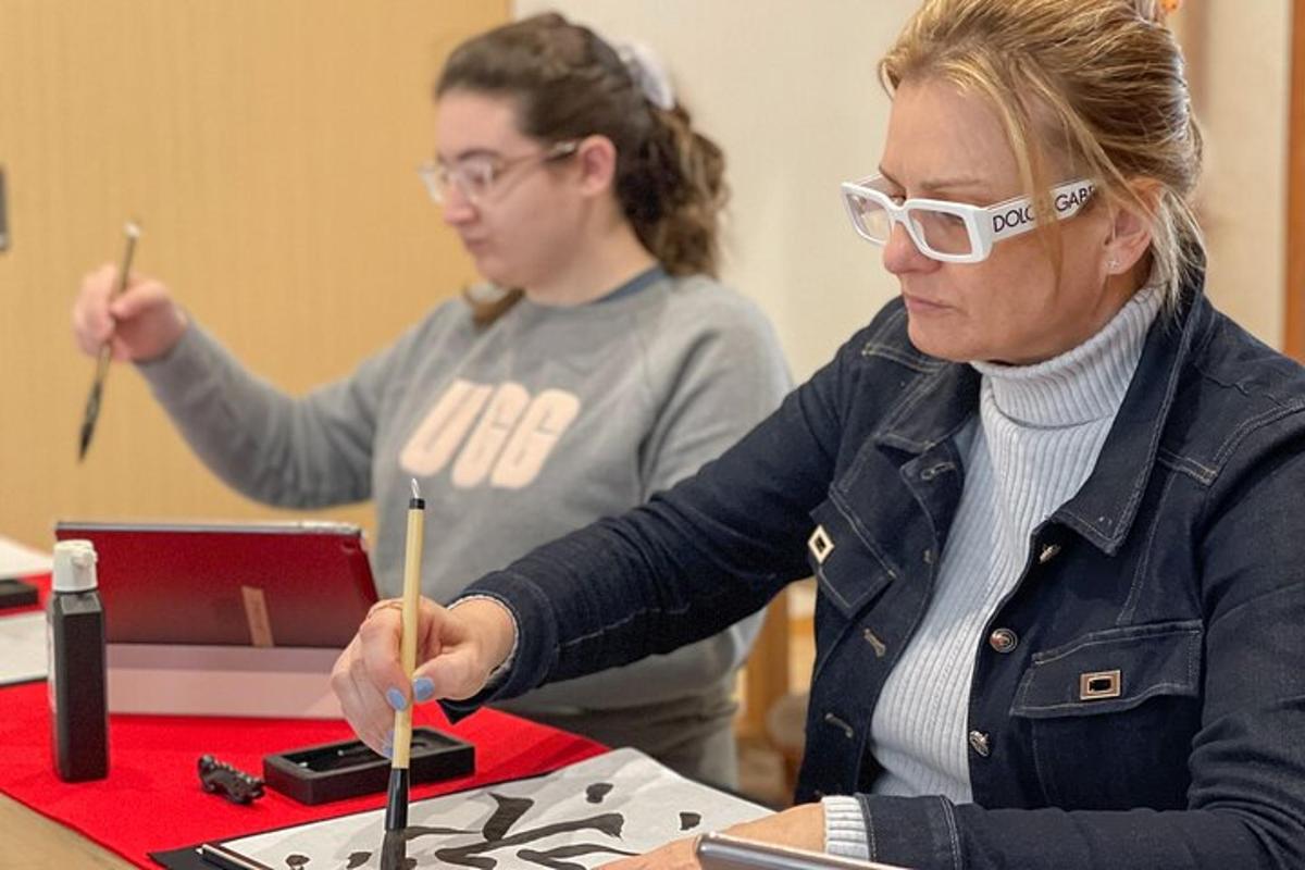 duas mulheres sentadas à mesa trabalhando em um dispositivo