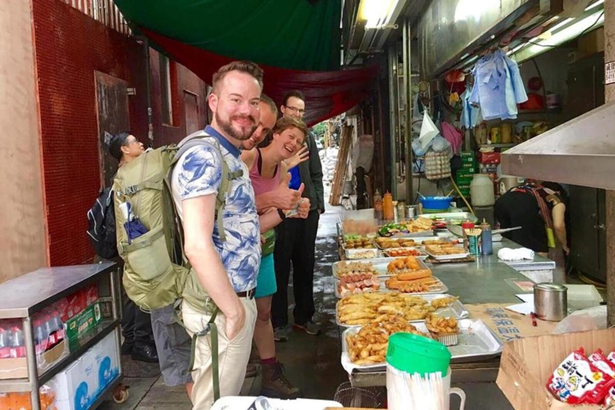 a man and a woman standing in front of a food stand