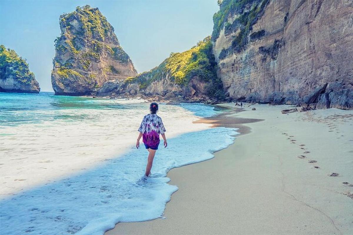 una donna che cammina su una spiaggia vicino all'oceano