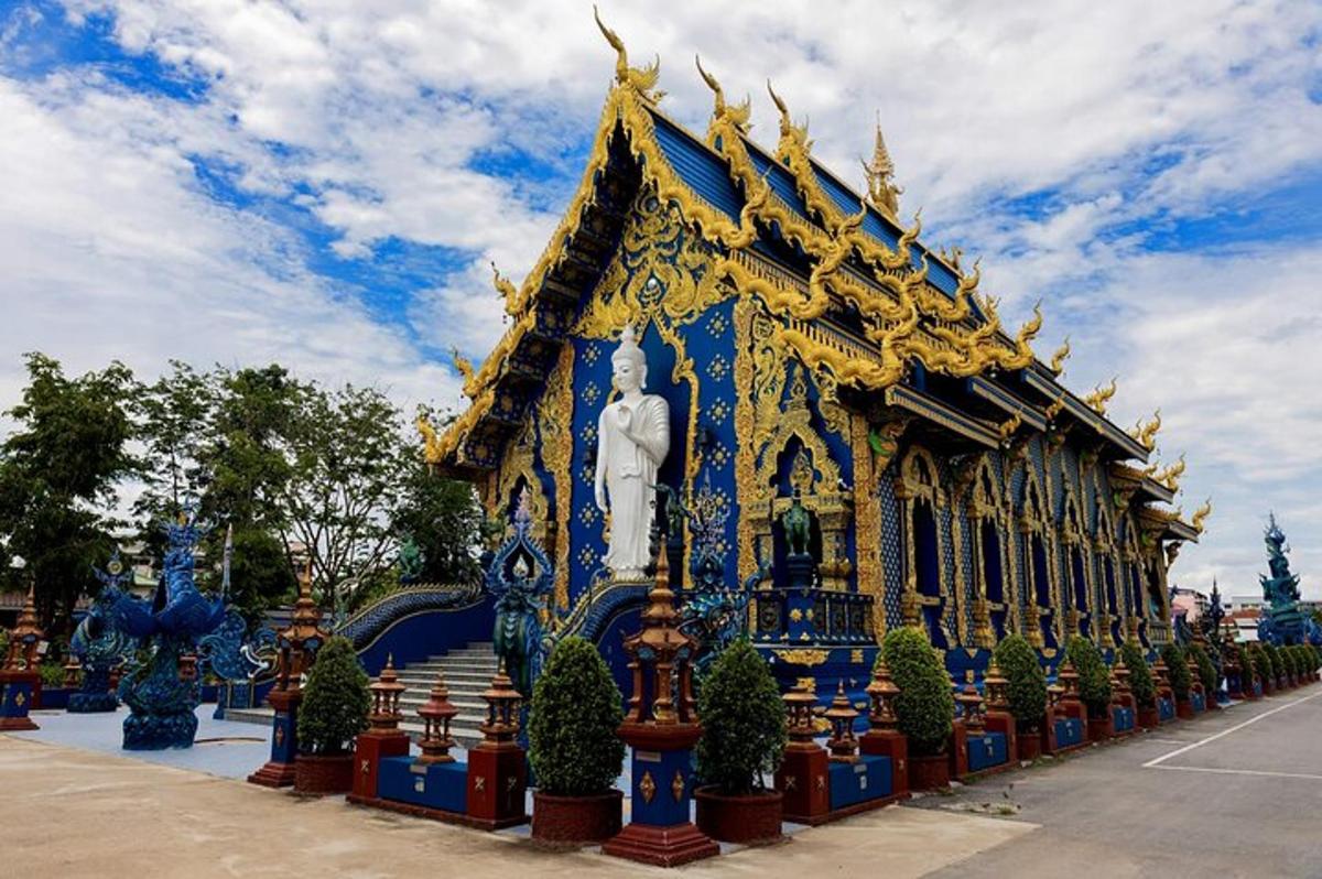 một tòa nhà màu xanh và vàng có một bức tượng trên đó