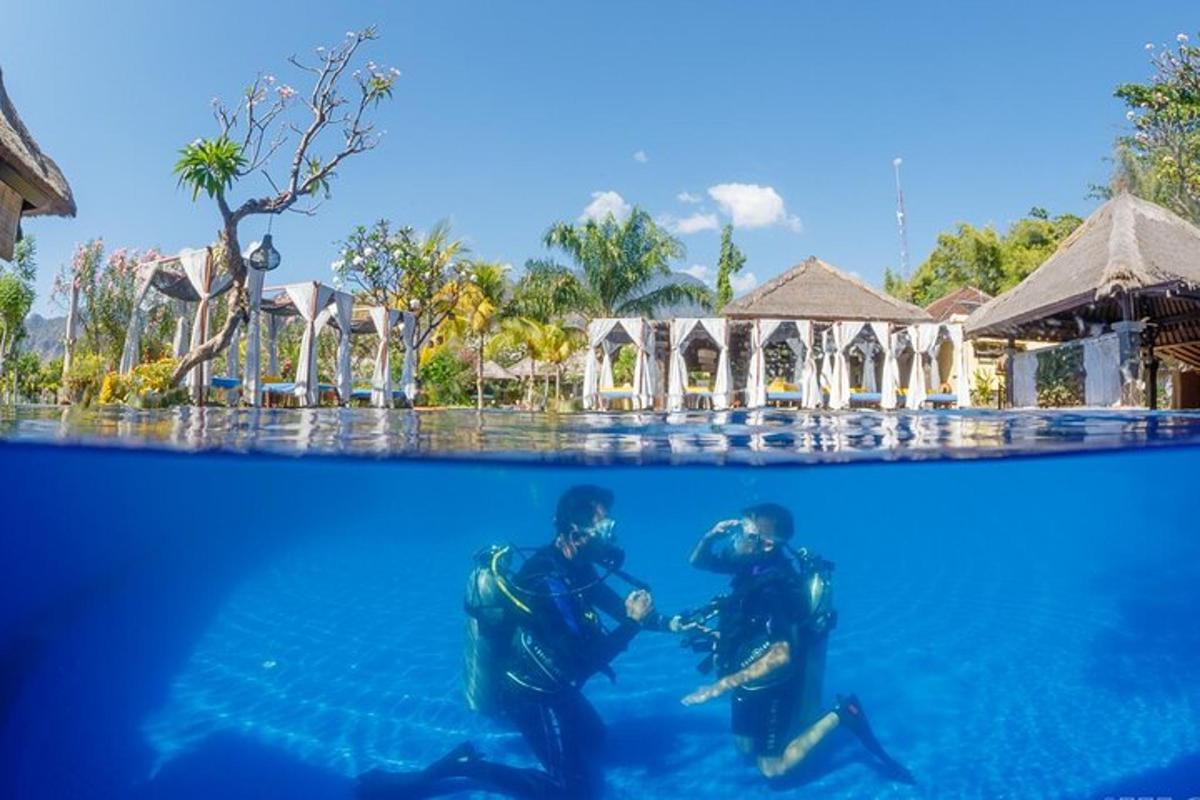 two people in the water in front of a resort