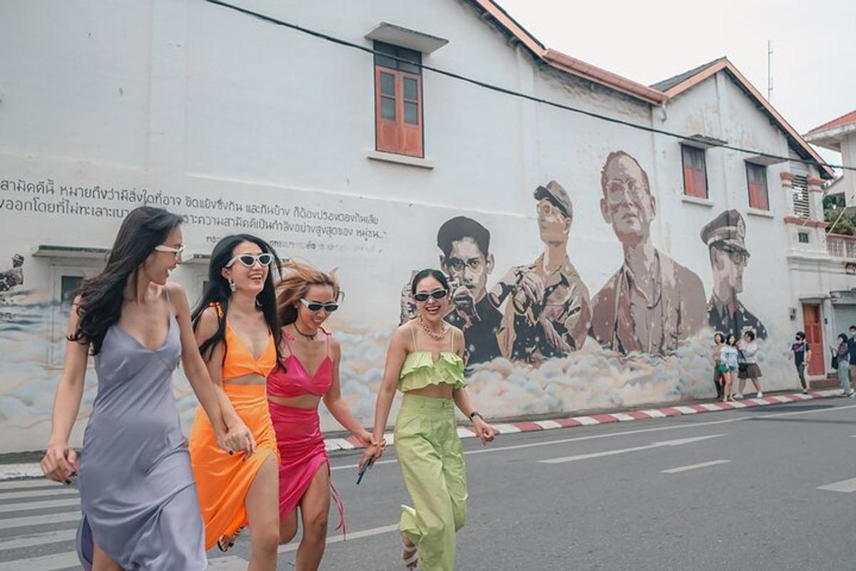 quattro donne che camminano lungo una strada davanti a un murale