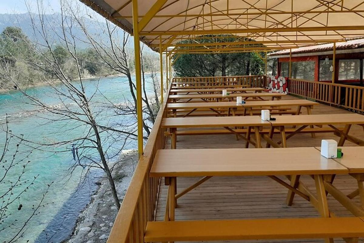 Una fila de mesas en una terraza junto a un río