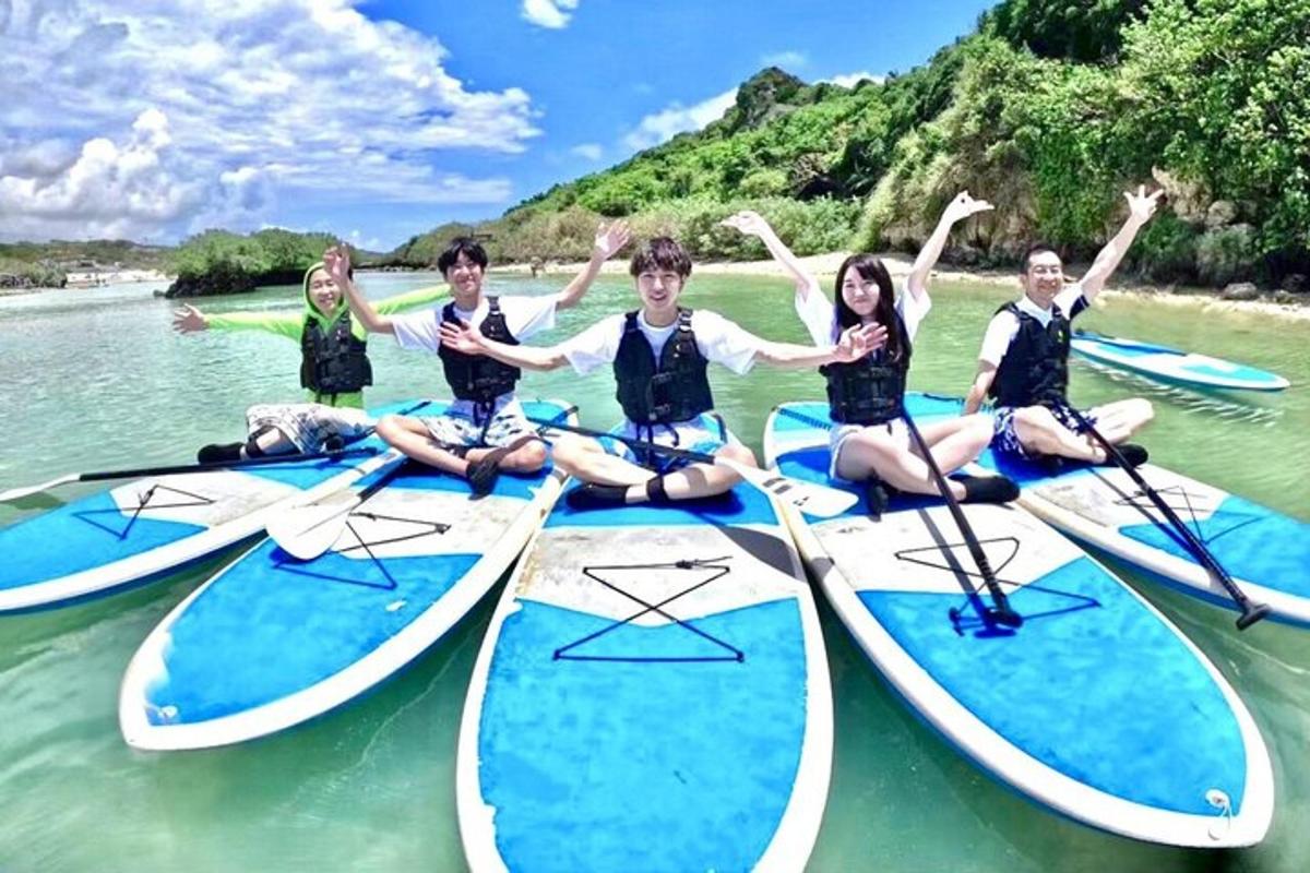 a group of people sitting on paddle boards in the water