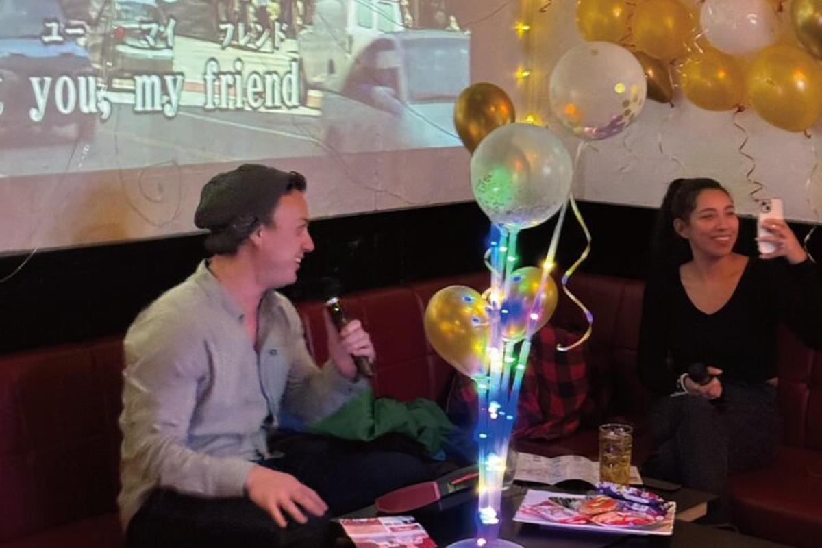 a man and a woman sitting on a couch with balloons