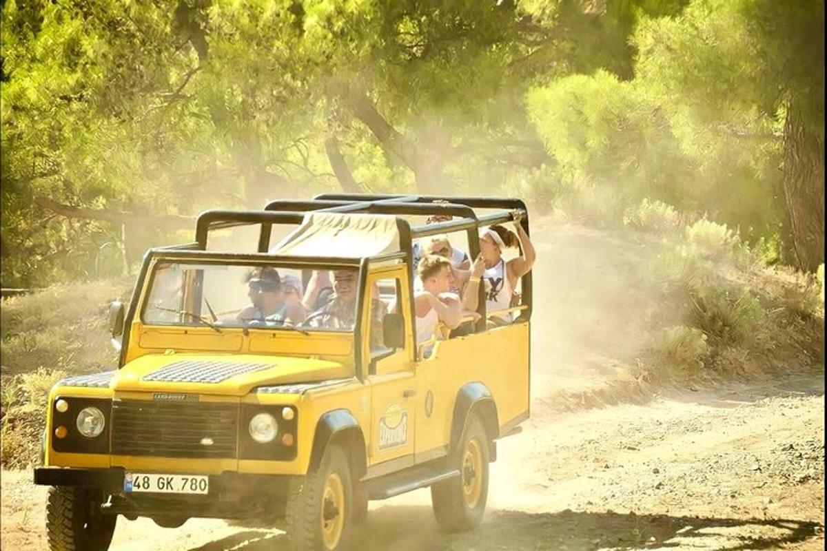un groupe de personnes circulant dans une jeep jaune sur un chemin de terre