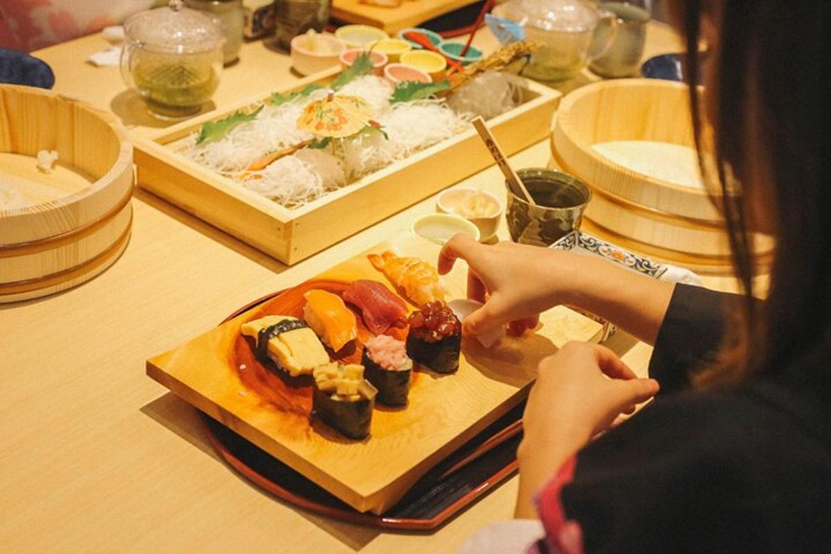 kona situr við borð með disk af sushi