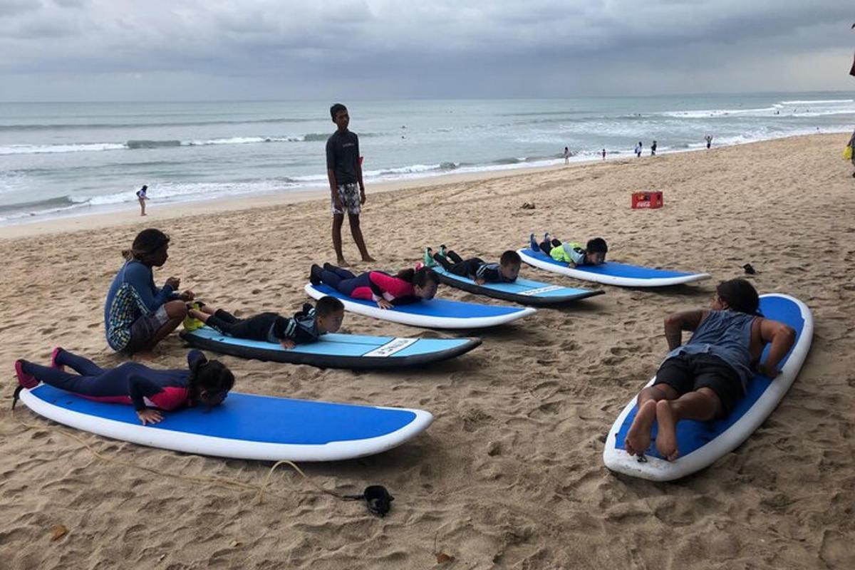 sekumpulan orang berbaring di atas papan luncur di pantai