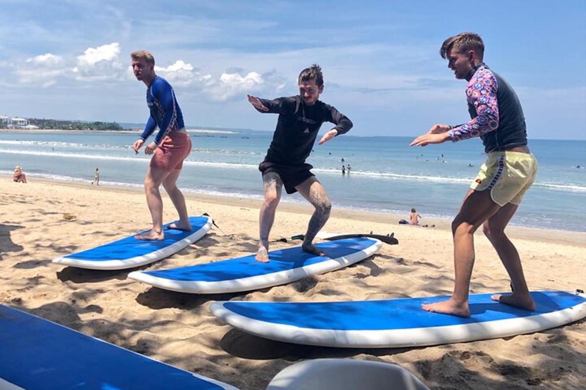 tiga lelaki berdiri di atas papan luncur di pantai
