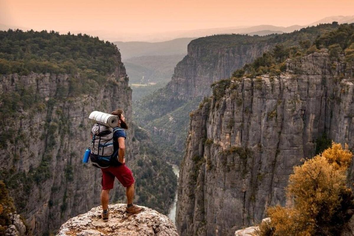 Un hombre con una mochila de pie en la cima de una montaña