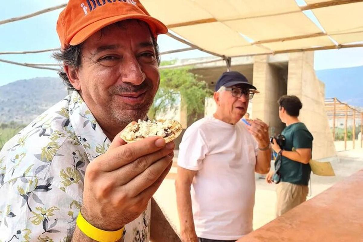 two men are eating food at a table