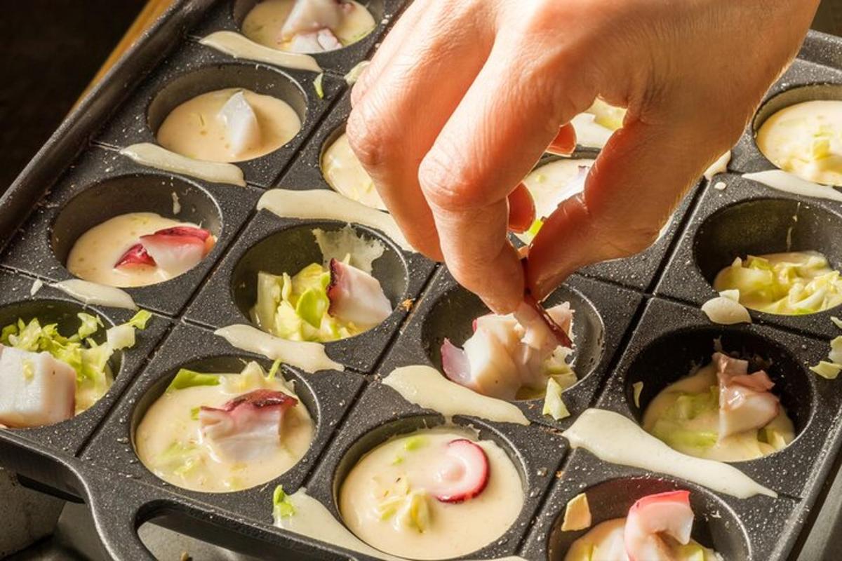 a person reaching into a muffin tin of food
