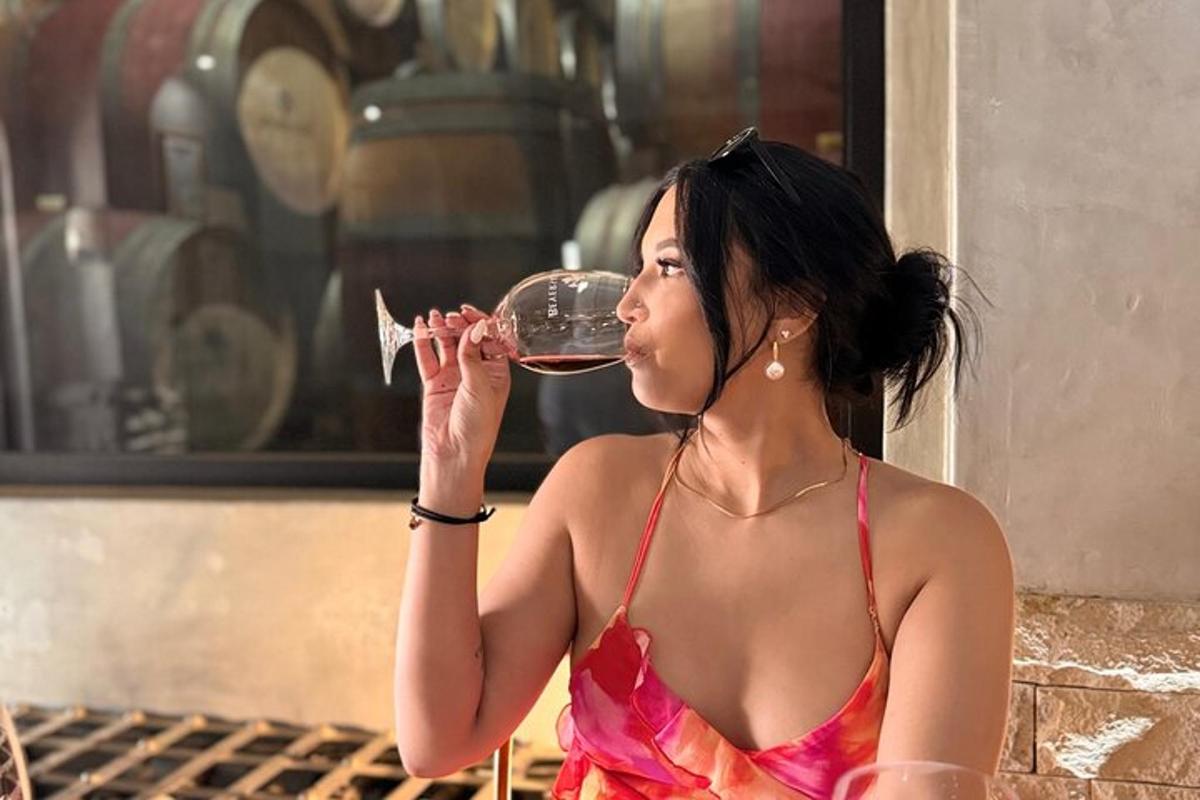 een vrouw in een jurk die een glas wijn drinkt