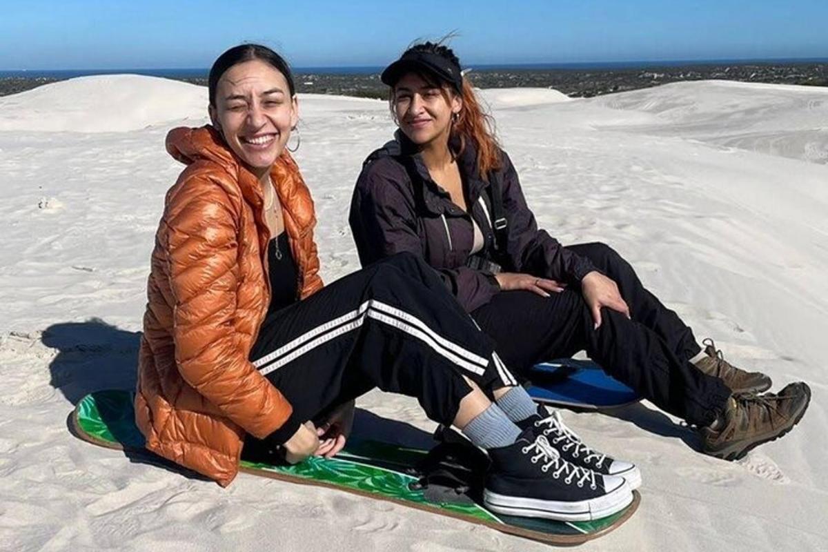 dwie osoby siedzące na snowboardzie na śniegu