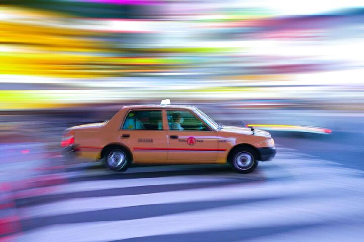 um carro laranja está descendo a rua