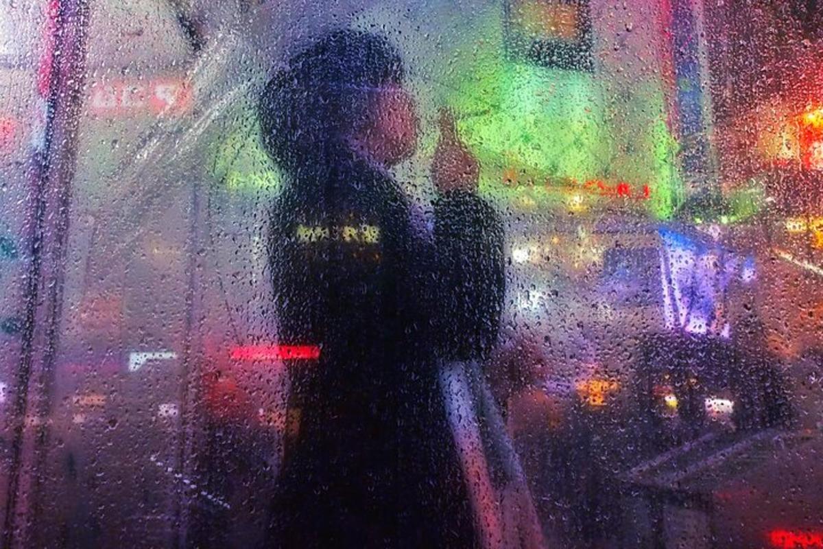 a person standing in the rain outside a window