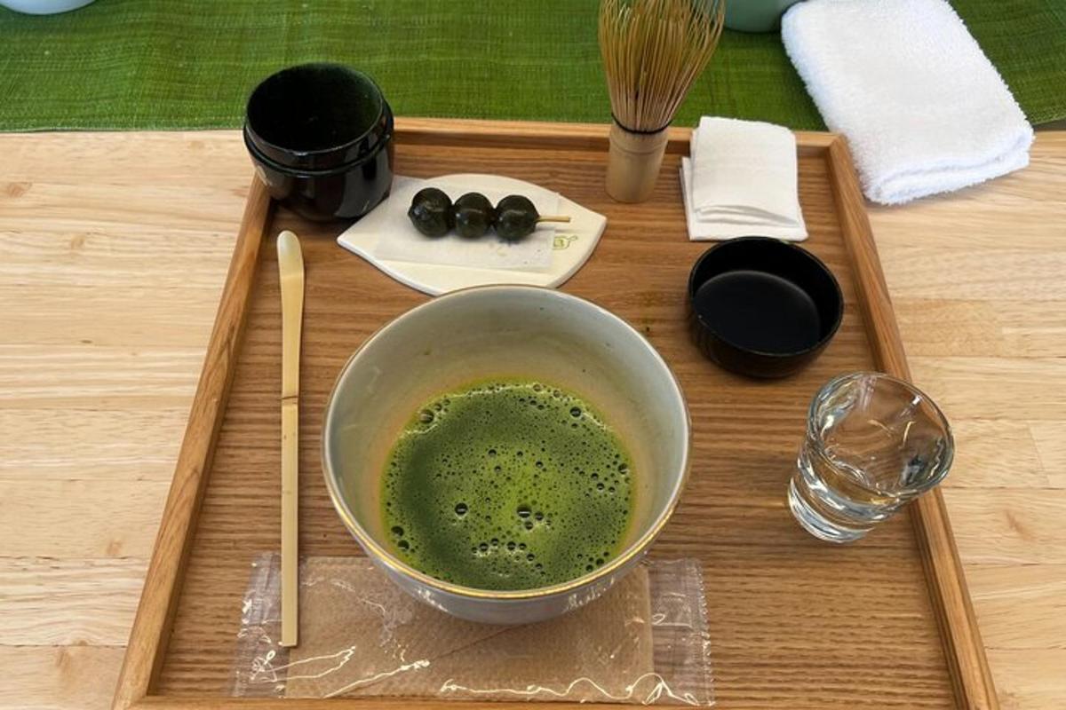 緑色の液体が入ったボウルと箸が置かれた木製のトレイ