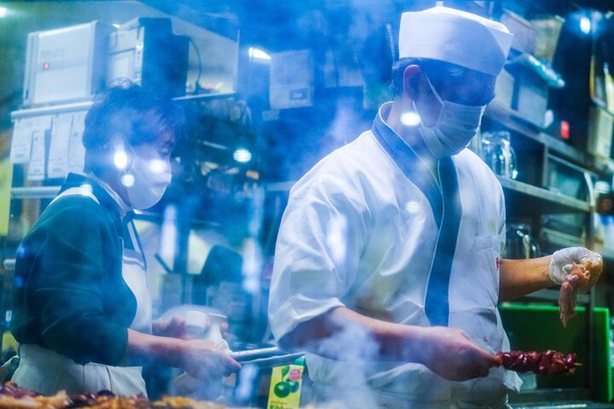 dois chefs em pé em uma cozinha preparando comida