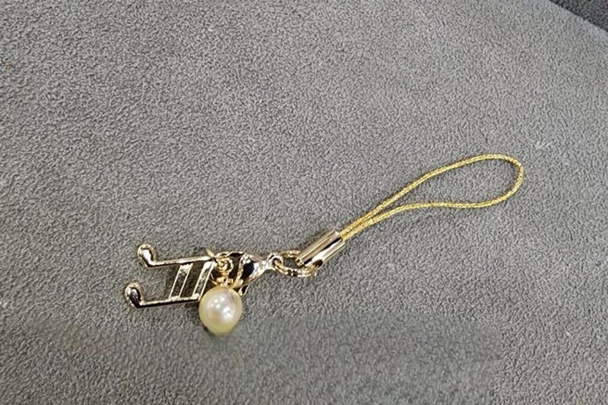 una arracada de perla està lligada a un fil d'or