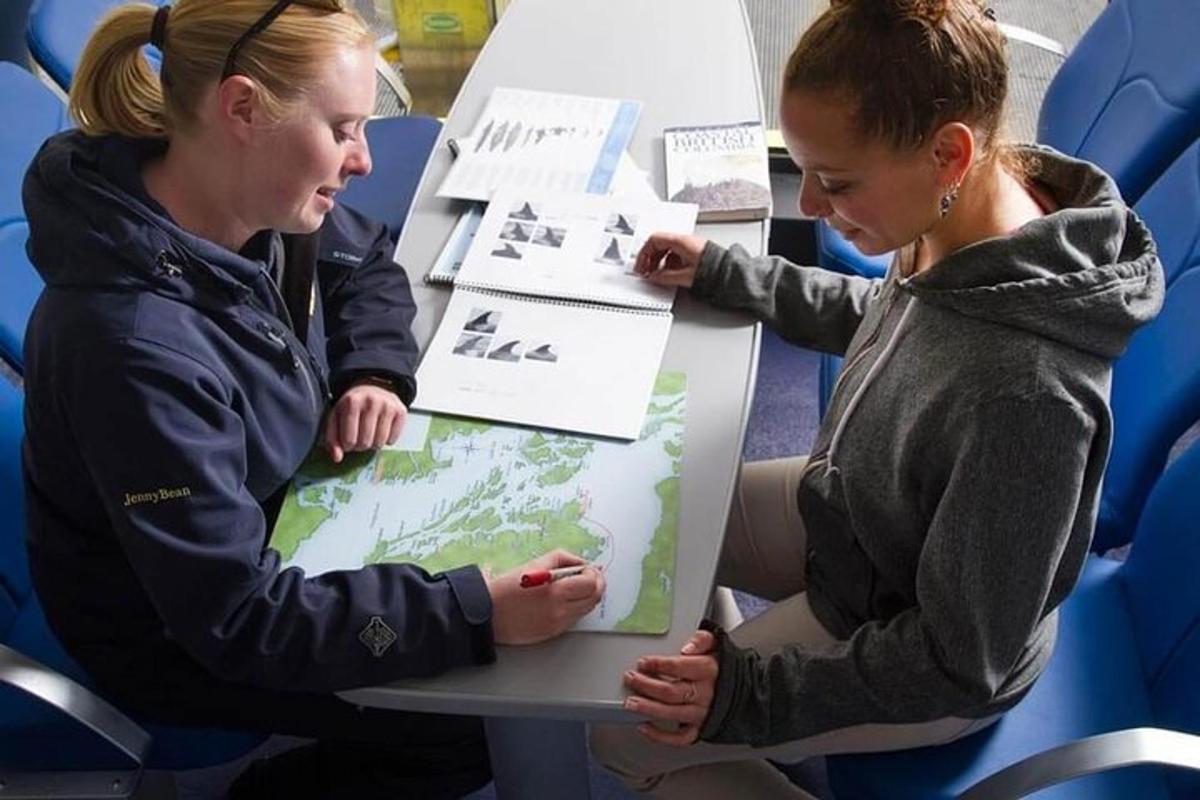 two women sitting at a table looking at a map