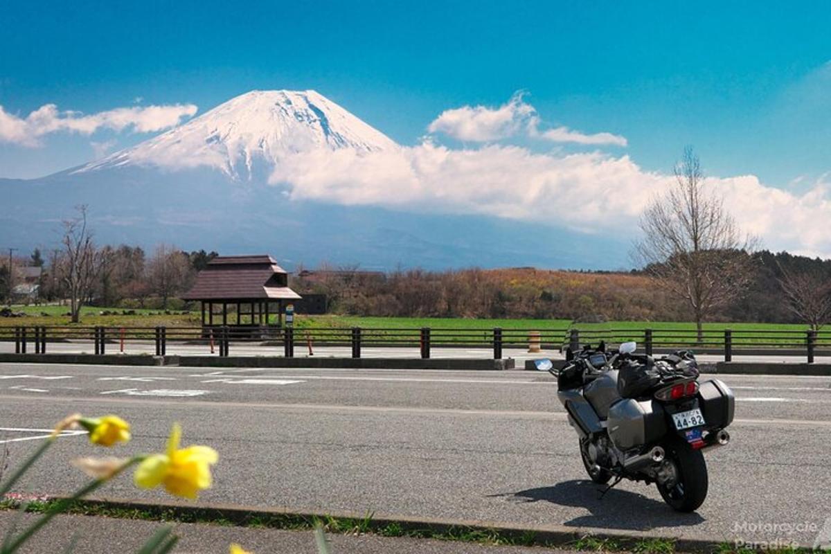 sebuah motosikal diletakkan di tepi jalan dengan gunung