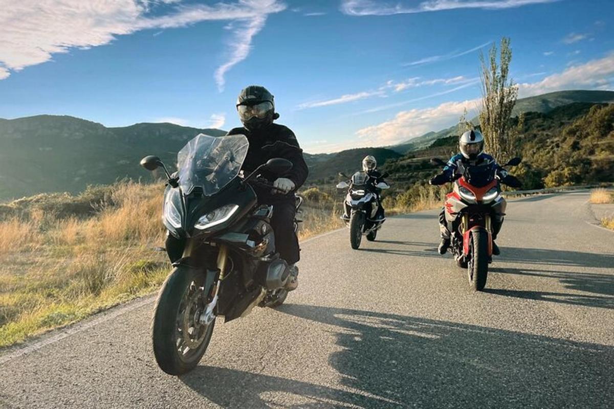 a group of people riding motorcycles down a road