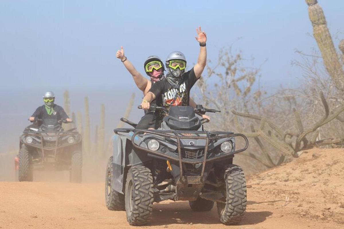 dva lidé jedoucí na čtyřkolkách po nezpevněné cestě