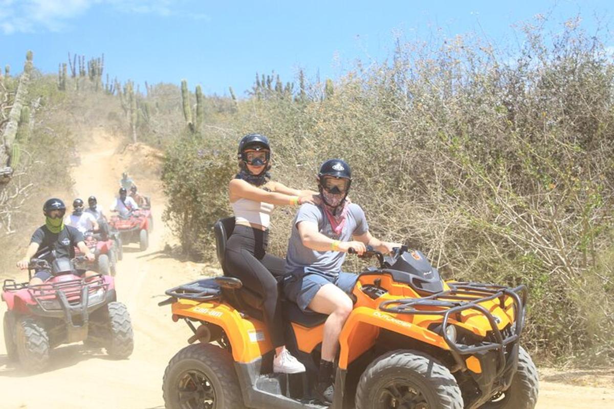 a group of people riding on atvs on a dirt road