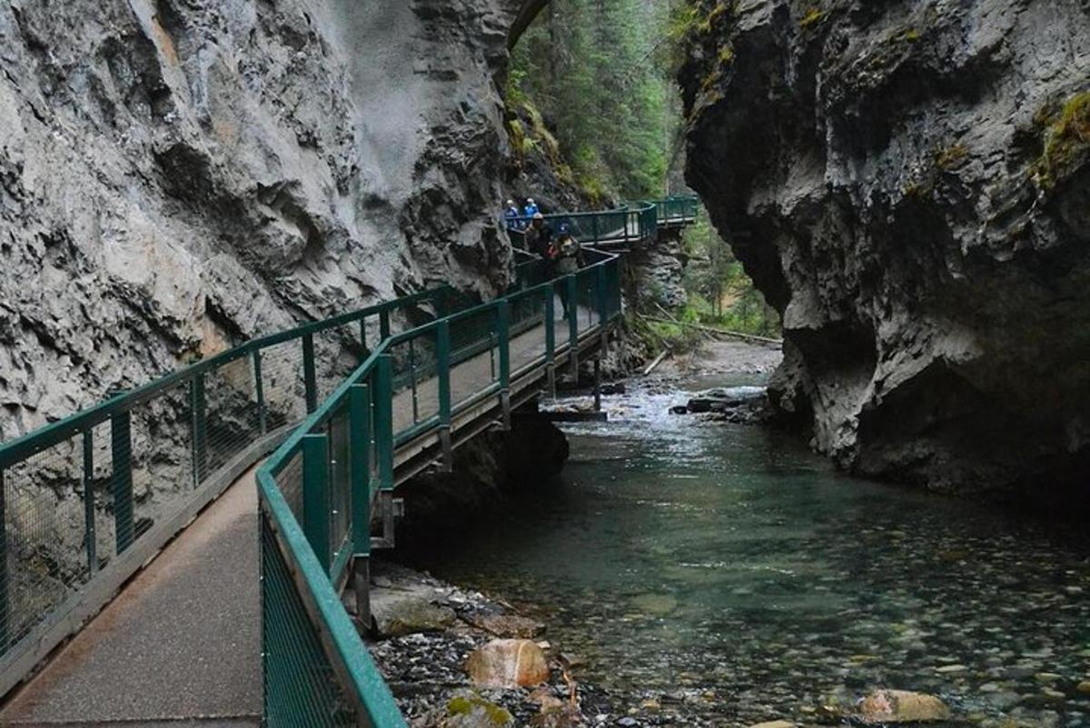 a bridge over a river next to a mountain