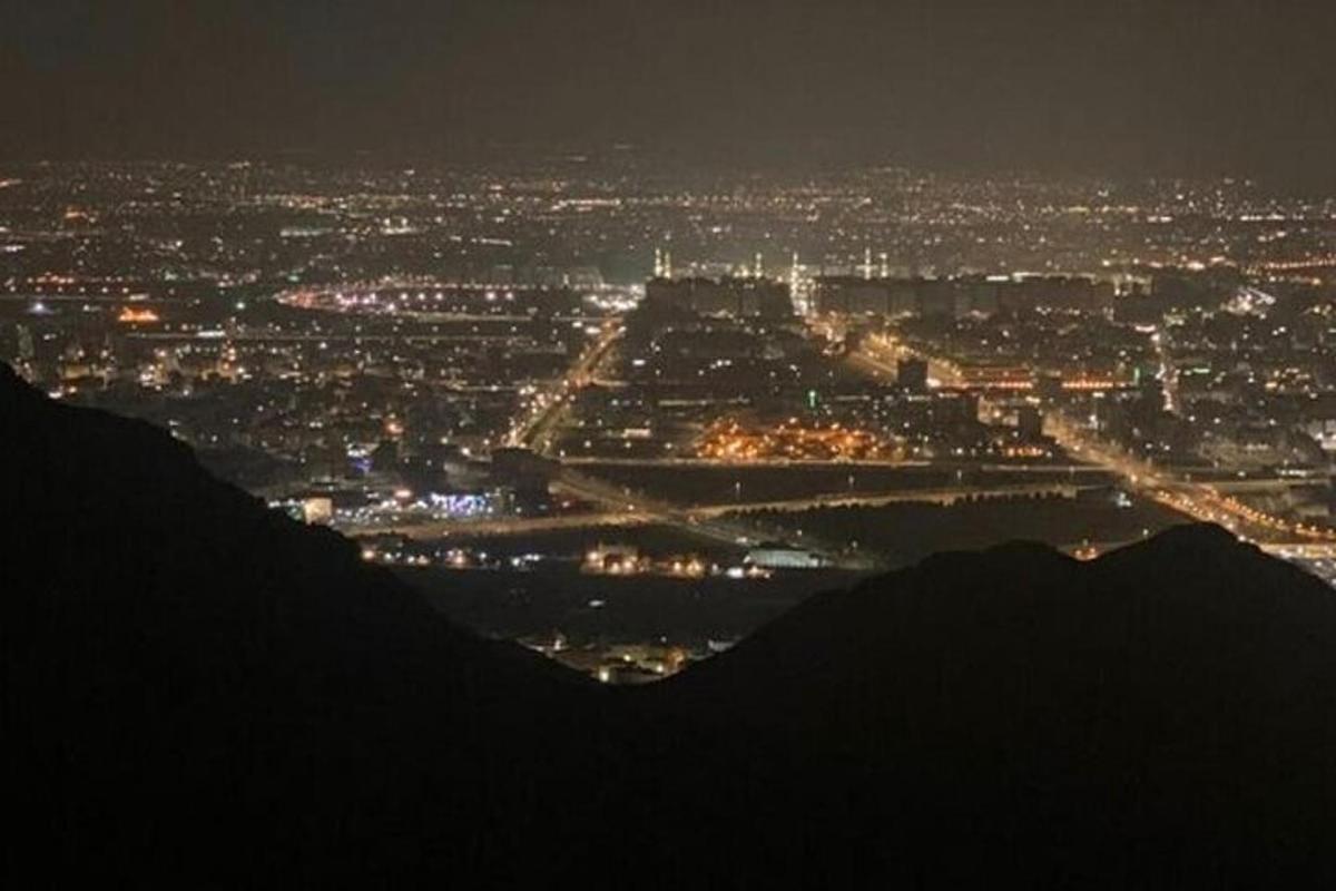 a view of a city at night from a hill