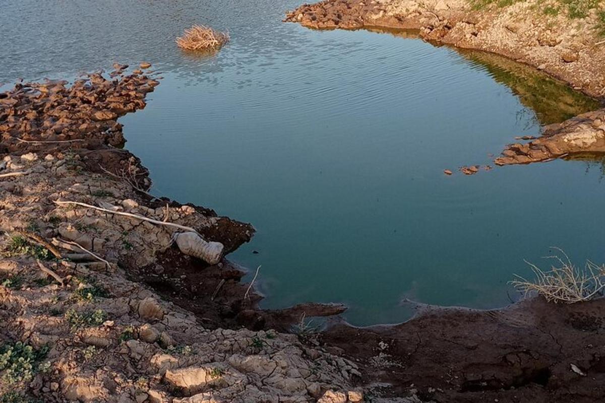 a small pool of water on the side of a river