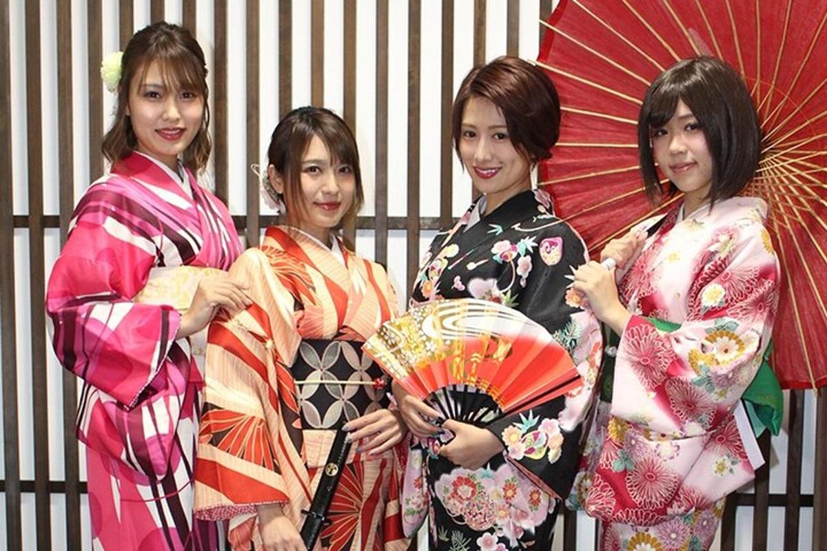 four women in kimonos are holding umbrellas