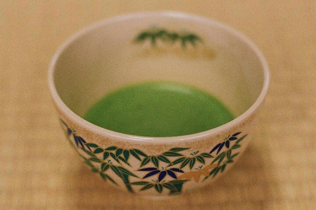 a cup with green liquid in it sitting on a table