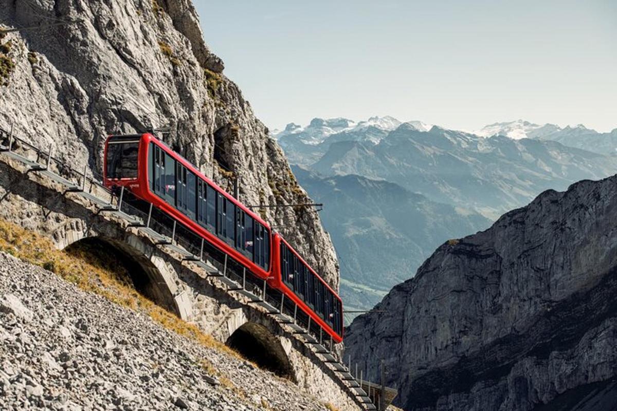 un treno rosso è su una scogliera di montagna