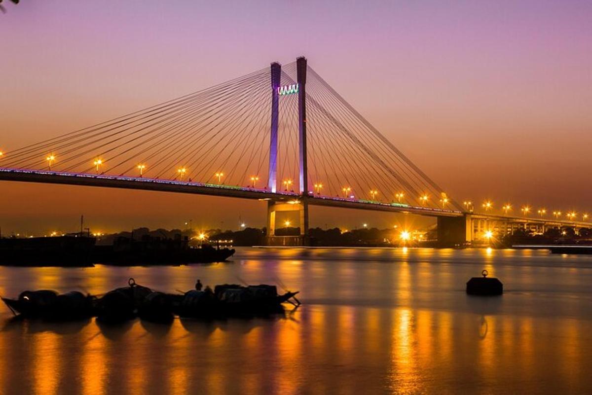 a bridge over a river at night with boats in the water