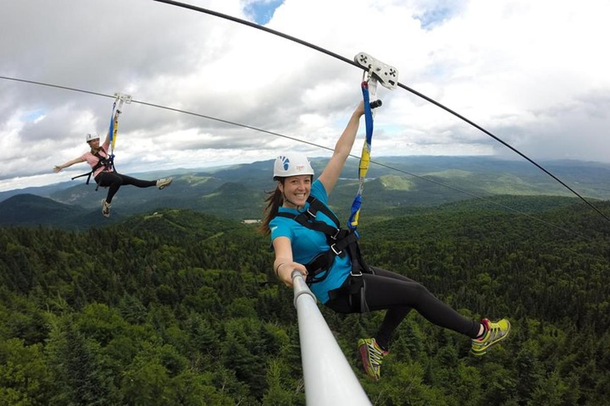 two women zip lining on a zip line in the mountains