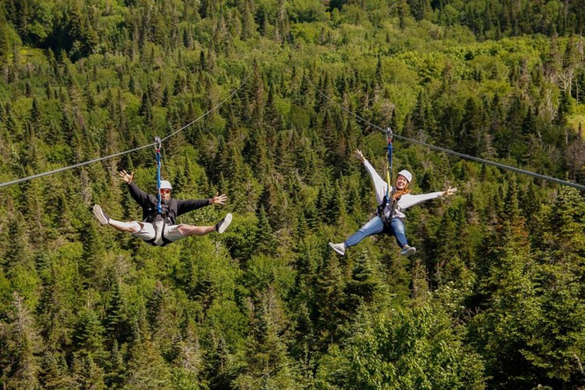 two people are hanging on a zip line