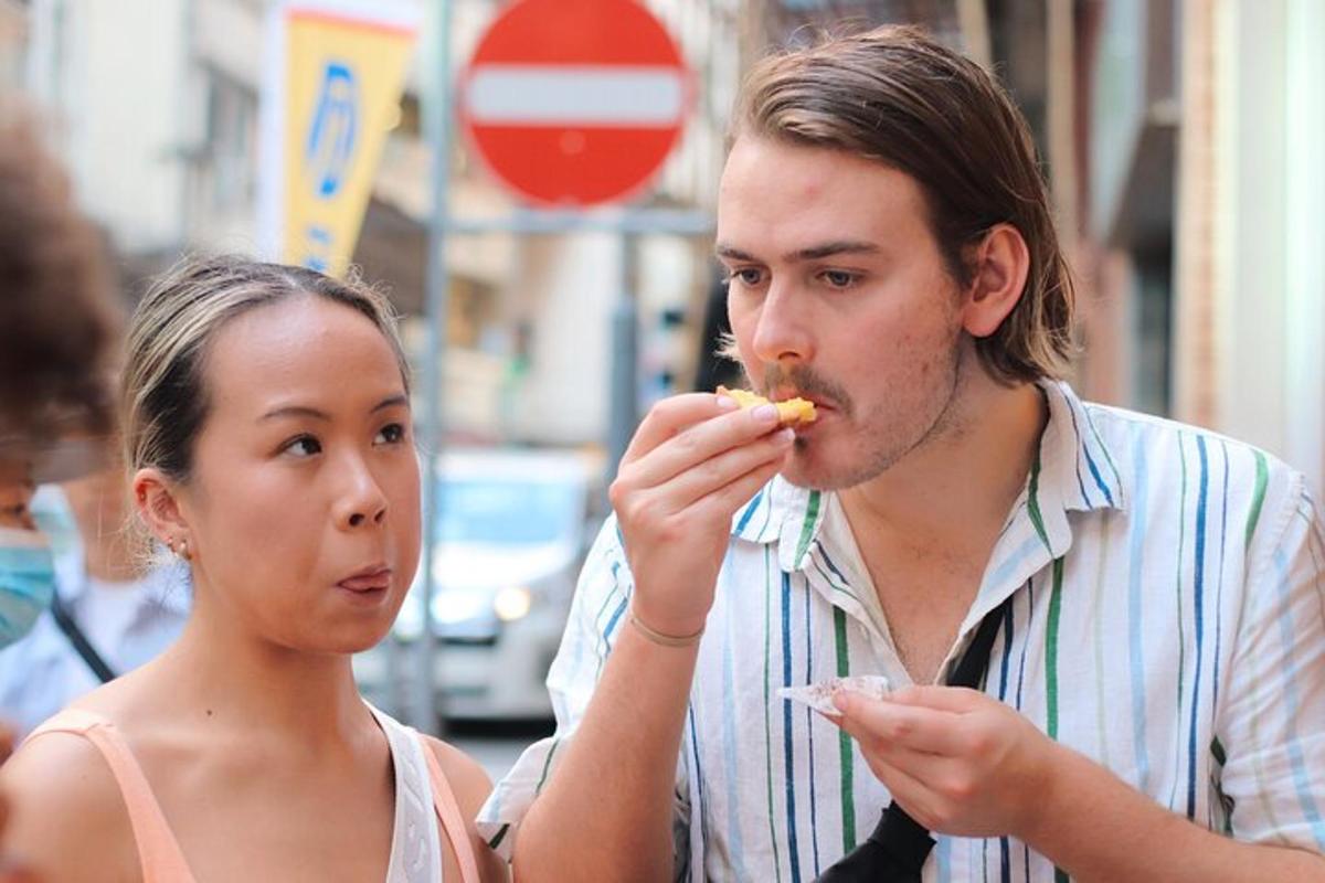 a man and a woman eating food on the street