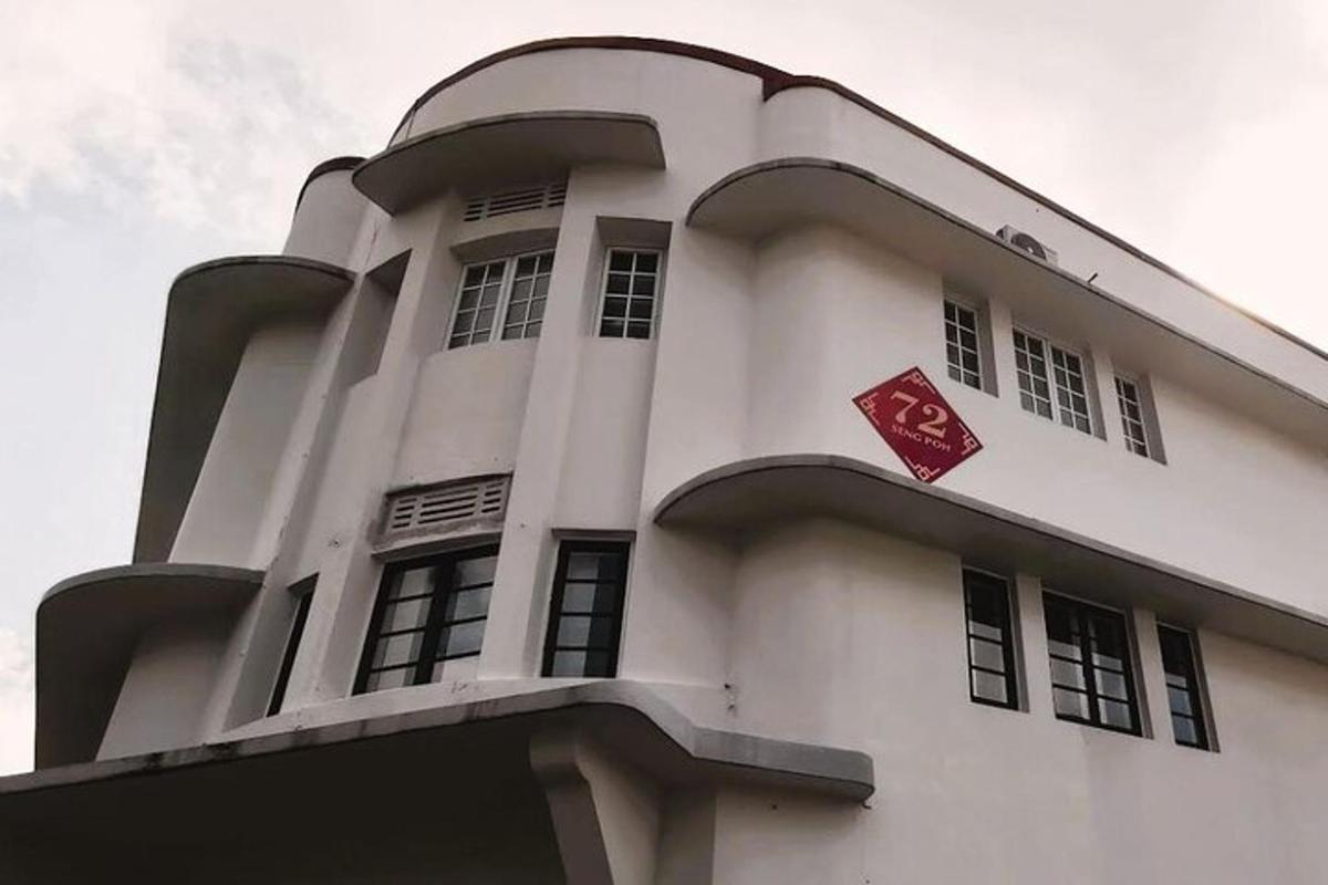 Un edificio blanco con un cartel rojo encima.