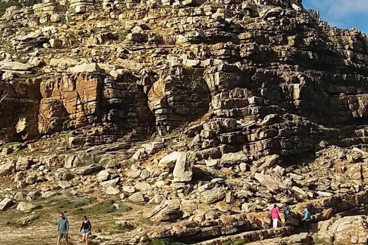 un gruppo di persone che camminano su una montagna rocciosa