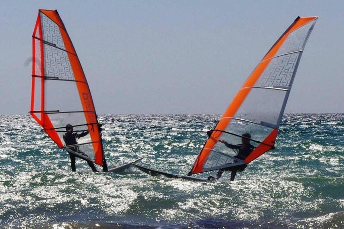 Dos personas están haciendo windsurf en el océano.