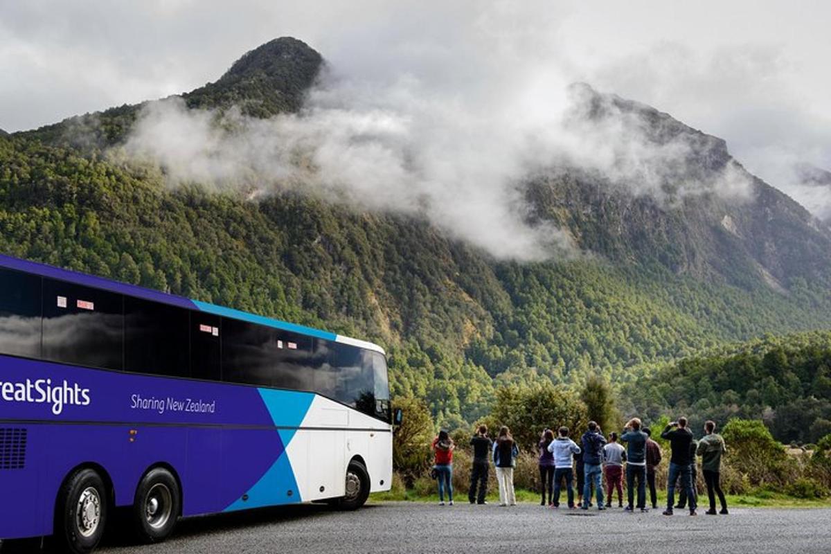 un grup de oameni care stau în fața unui autobuz